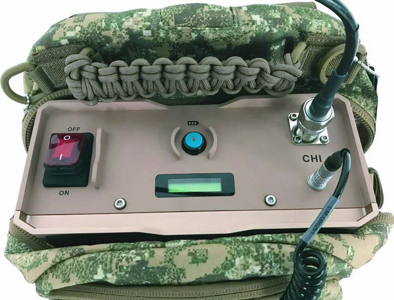 WF-U-MKS manpack jammer with control panel resting on camouflage fabric